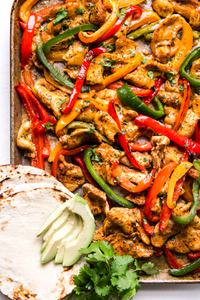 freezer chicken fajita meal on a sheet pan for dinner with tortillas and avocado and bell peppers