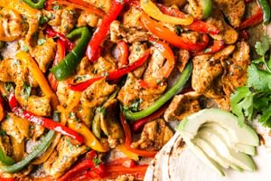 freezer chicken fajita meal on a sheet pan for dinner with tortillas and avocado and bell peppers
