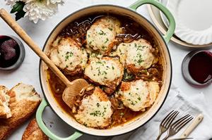 french onion chicken topped with Gruyère cheese being scooped out of a skillet
