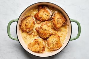 chicken thighs seasoned with salt and pepper being browned in olive oil in a skillet