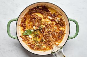 butter, nutmeg, thyme, bay leaf, garlic, salt, pepper and white wine being added to a skillet with cooked onions