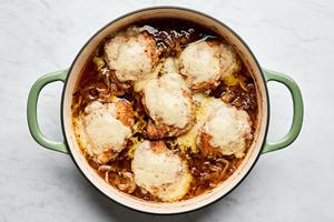 French onion chicken topped with Gruyère cheese in a skillet coming out of the oven