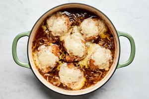 French onion chicken topped with Gruyère cheese in a skillet coming out of the oven