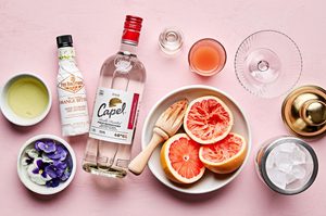 ingredients laid out for a Grapefruit Pisco Sour with Orange Bitters cocktail: pisco, grapefruit juice and bitters