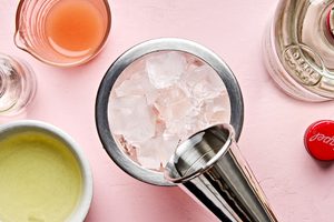 ingredients for a Grapefruit Pisco Sour with Orange Bitters being added to a cocktail shaker with ice
