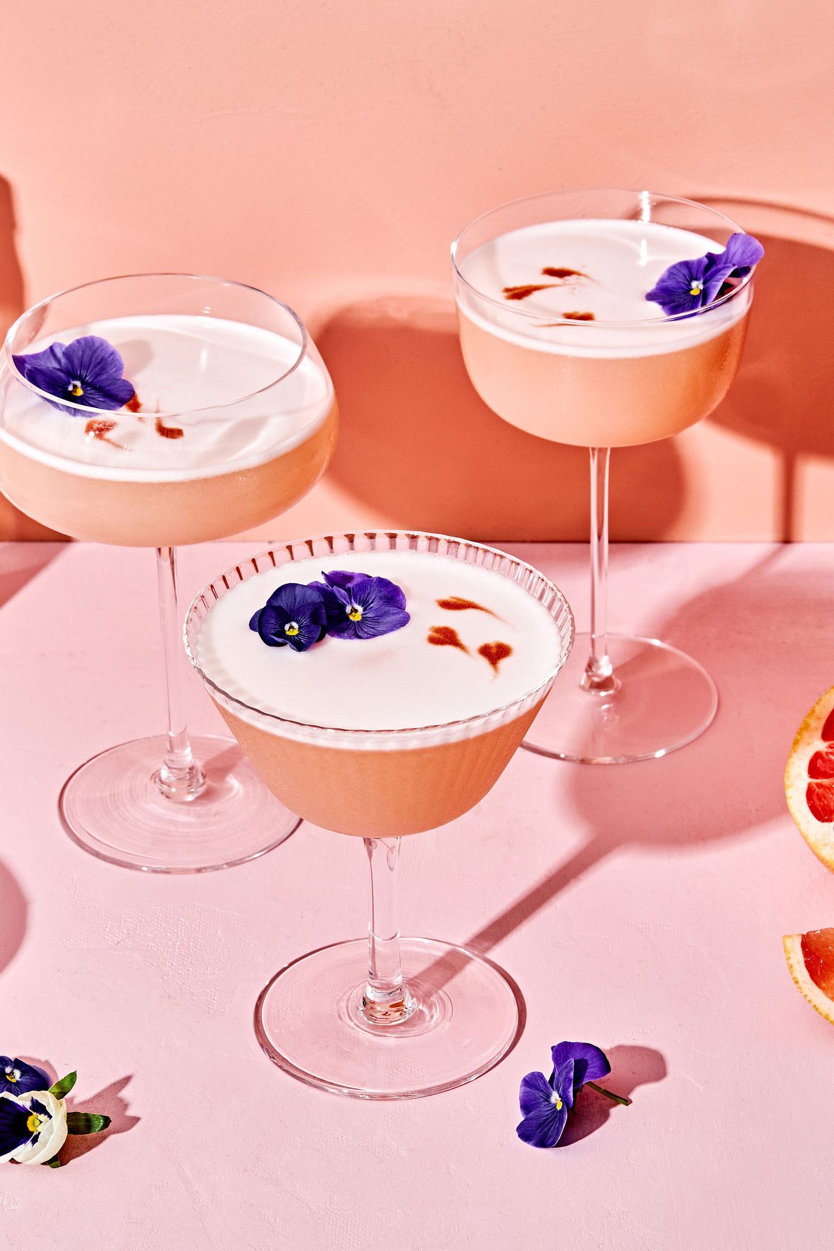 grapefruit pisco sour with orange bitters cocktails garnished with flowers