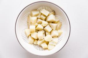 potatoes being strained in a colander
