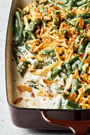 homemade green bean casserole with a creamy sauce and topped with French fried onions in a casserole dish