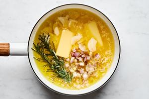 butter, olive oil, shallot, garlic, and rosemary sprigs cooking in a pot