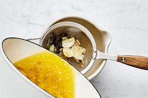herb butter being strained into a bowl