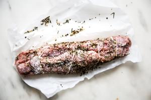 Herb crusted Pork Tenderloin with kosher salt on parchment paper