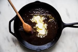 butter and port being mixed into pan drippings from a rostasted pork tenderloin