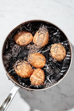 6 eggs being boiled in a pot of water