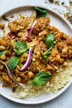 Instant pot chicken tagine over cous cous on a white plate