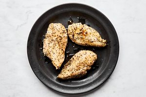 perfectly cooked and seasoned chicken breast fresh out of the instant pot resting on a plate