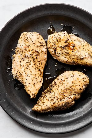 perfectly cooked and seasoned chicken breast fresh out of the instant pot resting on a plate