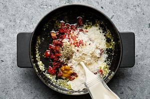 creamy sun-dried tomato sauce being made in a skillet for marry me salmon