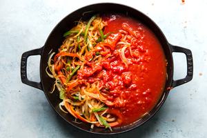 tomato sauce and crushed tomatoes with bell peppers and onions in a large skillet
