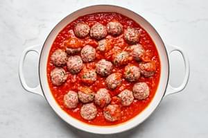 the perfect ground beef and ground italian sausage meatballs simmering in marinara sauce