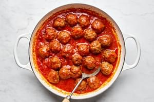 the perfect ground beef and ground italian sausage meatballs simmering in marinara sauce