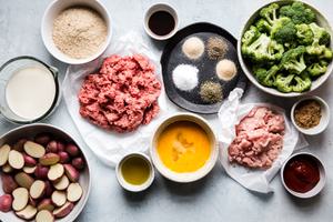 Ingredients for meatloaf dinner including broccoli, ground pork, ground beef, eggs, potatoes, bread crumbs, milk and ketchup