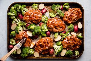 Pastry brush brushing brown sugar and Worcestershire sauce on raw meatloaf patties