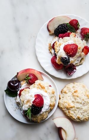two small plates with mixed berry shortcake and whipped cream