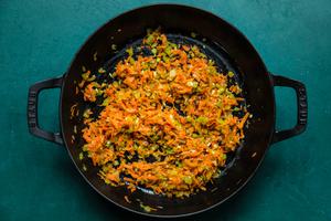 shallot, celery, carrots and garlic being cooked in olive oil in a saucepan for mushroom ragù