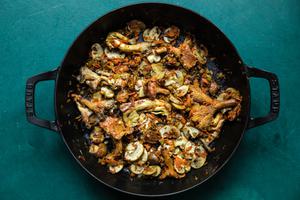 shallot, celery, carrots, garlic and mushrooms being cooked in olive oil in a saucepan for mushroom ragù
