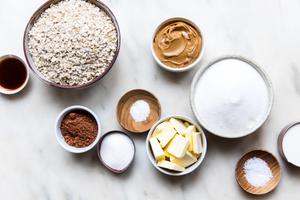 Milk, Butter, Cocoa powder, Sugar, Oats, Peanut butter, Vanilla and Salt in bowls on the counter to make no-bake cookies
