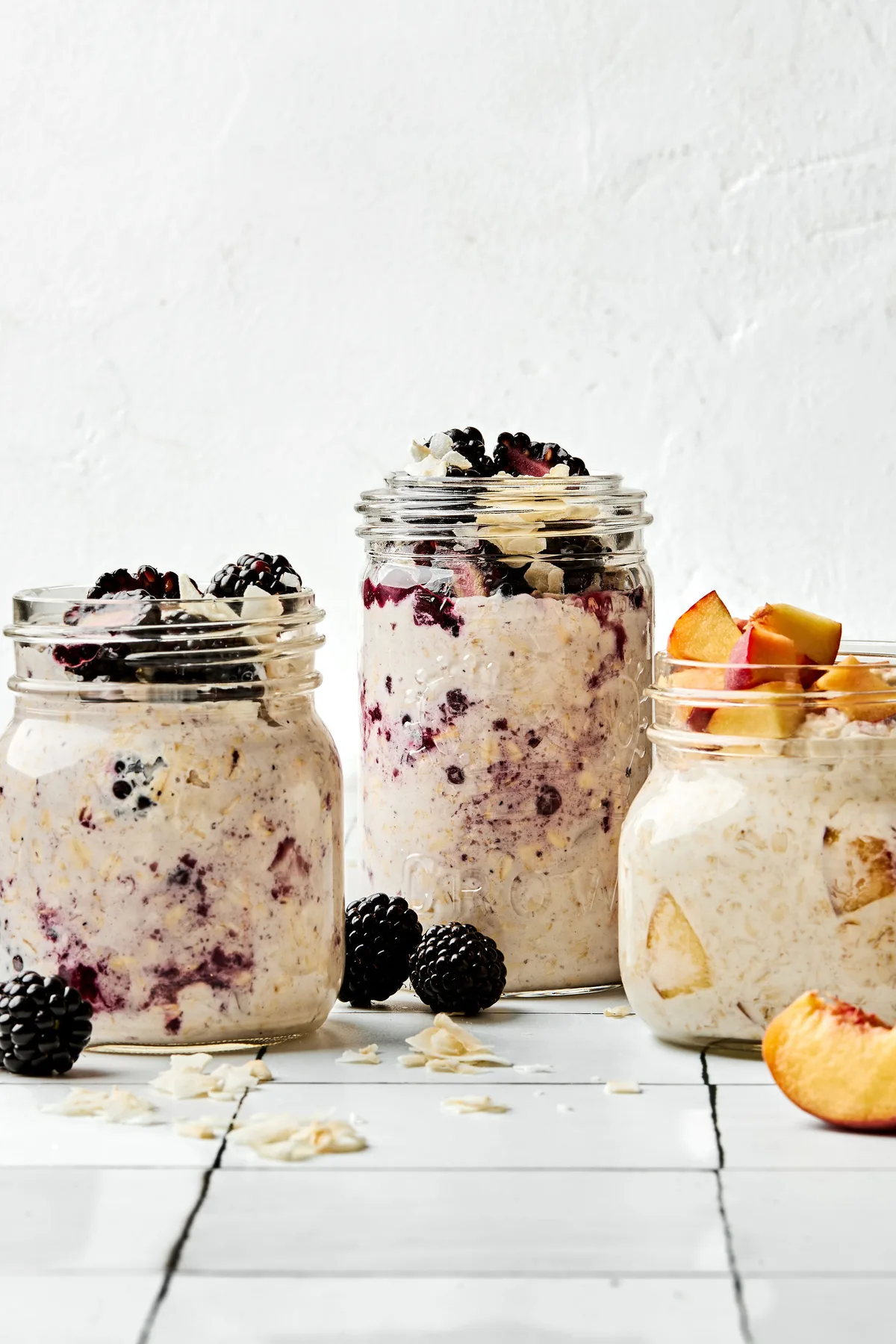 Three jars of overnight oats with various toppings: fruit, chia seeds, jam and coconut in a list of easy oat breakfast ideas