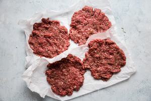4 raw beef patties made with ground beef, onion powder, garlic powder, salt, pepper and Worcestershire