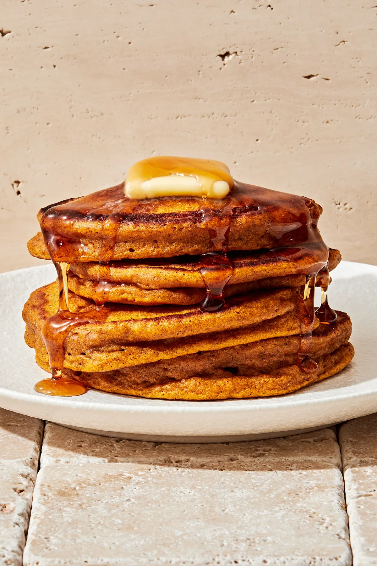 stack of homemade pumpkin pancakes topped with butter and dripping with maple syrup in a list of the best breakfast ideas
