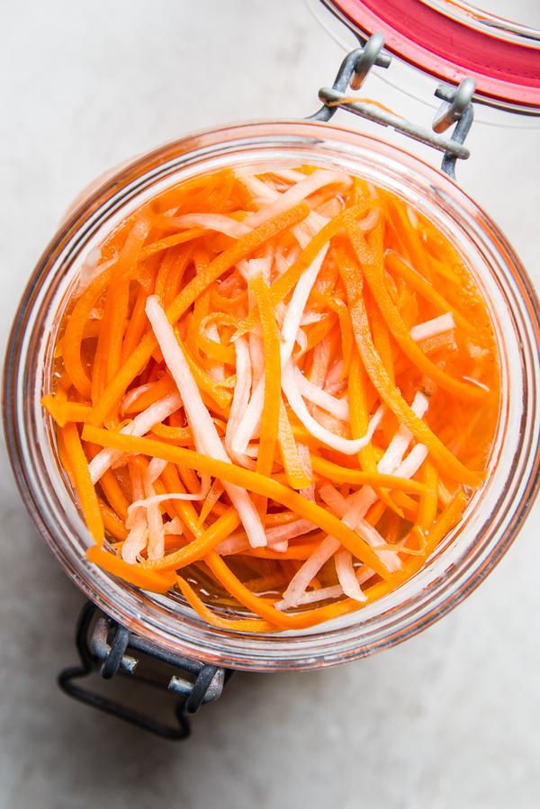 a glass jar of quick pickled carrots and radishes