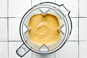 a blender full of quinoa bowl sauce made with almond flour, garbanzo beans, edamame, nutritional yeast, and spices