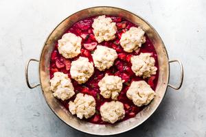 baked rhubarb topped with cobbler dough in a round baking dish