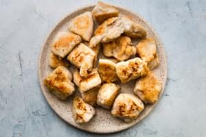browned chicken pieces on a plate for sesame chicken