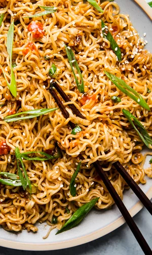 Sesame garlic ramen noodles on a plate with chopsticks