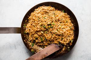 Sesame Garlic Ramen Noodles in a pan with green onions and stir fry sauce.