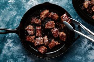 beef being browned in a cast iron skillet