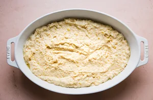 homemade spoon bread batter spread in a casserole dish that has been sprayed with non stick spray