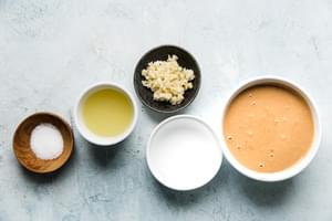 tahini, water, lemon juice, garlic and salt in bowls for tahini sauce