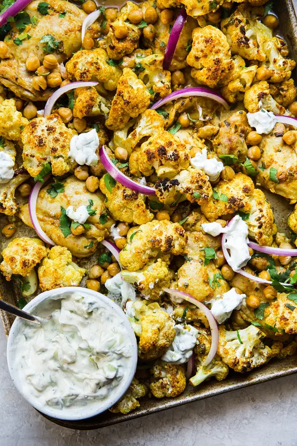 Tandoori Chicken Sheet Pan dinner with cauliflower, and chickpeas served with a bowl of Raita