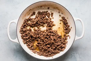 ground beef cooked in a large white skillet