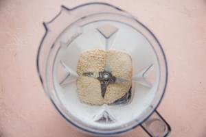 toasted rice shown blended in a blender until a fine powder is formed.