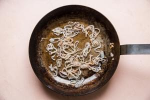 shallots shown in a large metal skillet