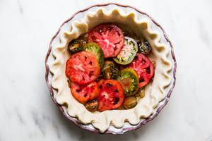 par-baked pie crust filled with caramelized onion and sliced tomatoes