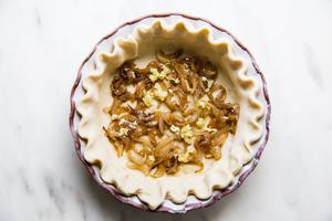 raw pie dough filled with caramelized onions and garlic