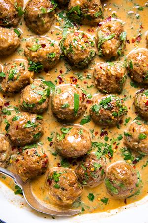 turkey meatballs in a red curry sauce topped with fresh cilantro and red pepper flakes