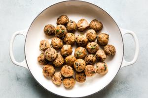 Browned Thai turkey meatballs browned in a large white skillet